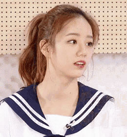 the girl is wearing a sailor uniform and a ponytail .
