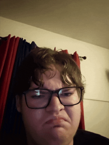 a man wearing glasses making a funny face