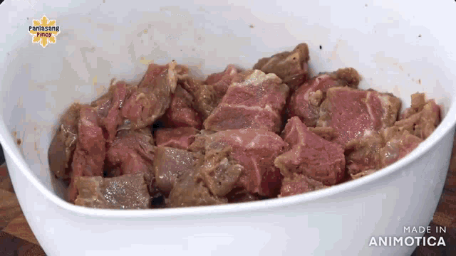 a white bowl filled with meat and the words made in animatica