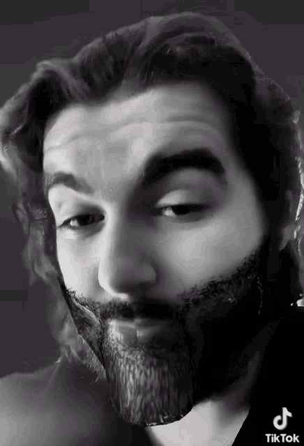 a black and white photo of a man with a beard and a tiktok watermark