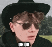 a young man wearing a cowboy hat and sunglasses .