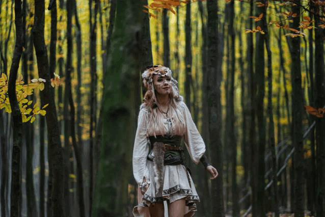 a woman in a white dress is standing in the woods