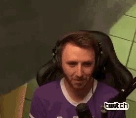 a man wearing headphones and a purple shirt is sitting in a chair .