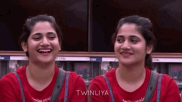 two women wearing red shirts with the word twinliya on them