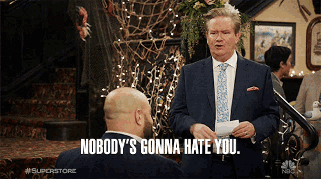 a man in a suit says " nobody 's gonna hate you " to another man