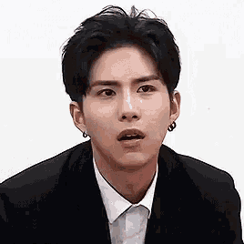a man in a suit and white shirt is making a funny face .