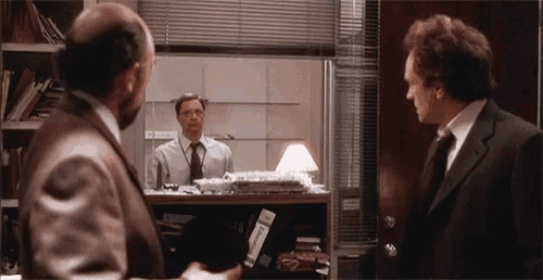 two men in suits and ties are standing next to each other in a room .