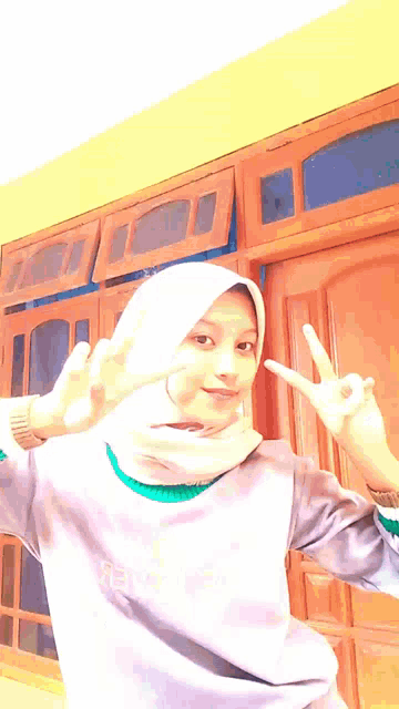 a girl wearing a white hijab and a purple shirt that says wow