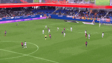 a soccer game is being played on a field with a banner that says ' barcelona ' on it