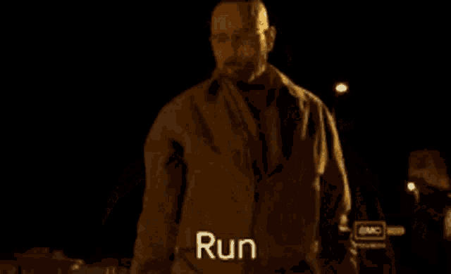a man with a beard and glasses says run in a dark room