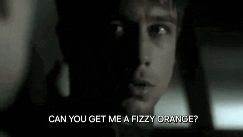 a close up of a man 's face with the words `` can you get me a fizzy orange ? '' written below him .
