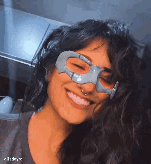 a woman wearing a mask on her face smiles for the camera ..