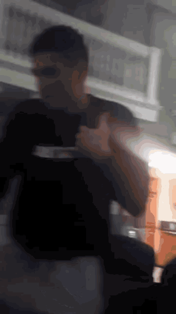 a blurry picture of a man in a black shirt holding a white plate