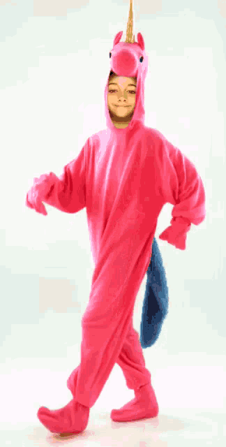 a little girl in a pink unicorn costume