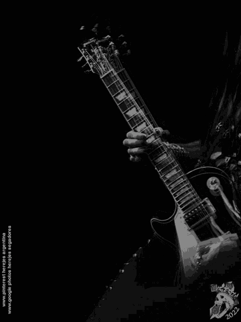 a black and white photo of a person playing an electric guitar with the year 2012 at the bottom