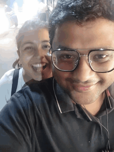 a man and a woman are posing for a picture and the woman is smiling