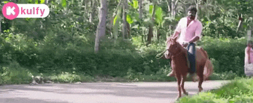 a man is riding a horse down a road in the countryside .