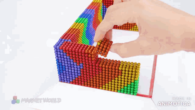 a person is playing with a rainbow colored toy made in animatica