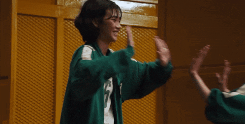 a woman in a green jacket with the number 26 on the front