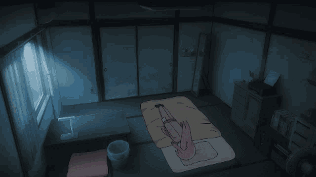 a person laying on a bed in a dark room with a trash can