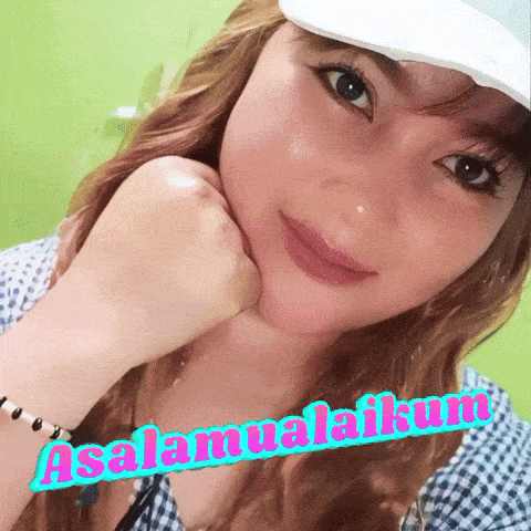 a woman wearing a white hat with the words assalamualaikum written on her face