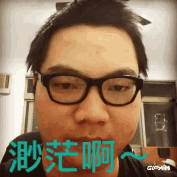 a man wearing glasses and a black shirt with chinese writing on it