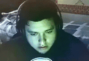 a man wearing headphones looks at the camera in a dark room .