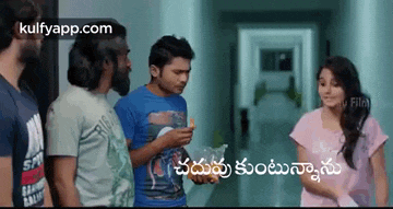 a group of people are standing in a hallway talking to each other in telugu .