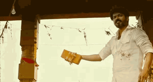 a man in a white shirt and hat is holding a wallet in his hand .