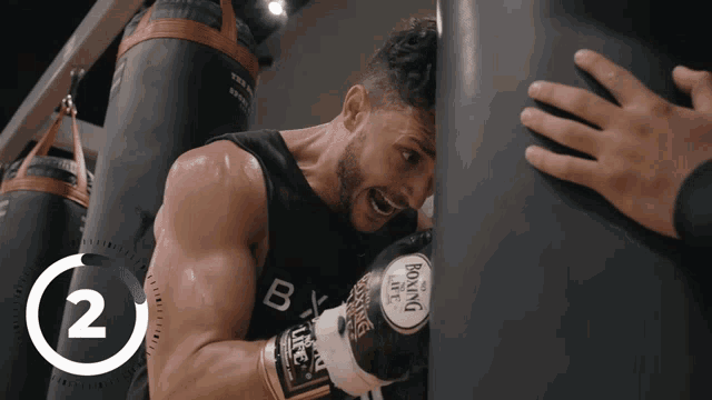 a man wearing boxing gloves with the number 2 on the bottom right
