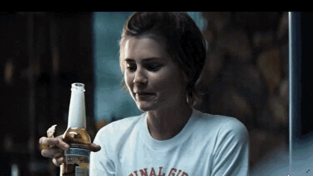a woman is holding a bottle of corona beer in her hand