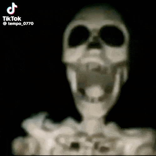 a close up of a skeleton with its mouth open in the dark