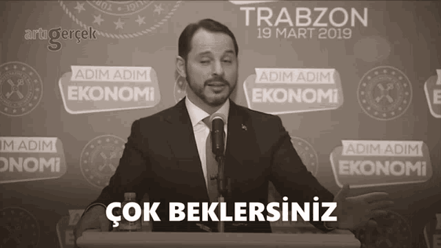 a man giving a speech in front of a trabzon poster
