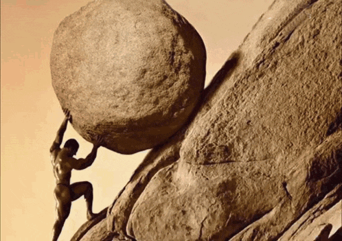 a man pushes a large rock up a hill