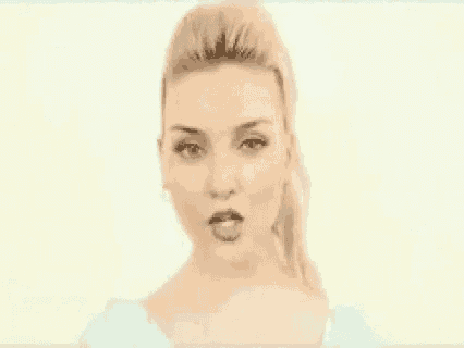 a close up of a woman 's face with her mouth open and a ponytail .