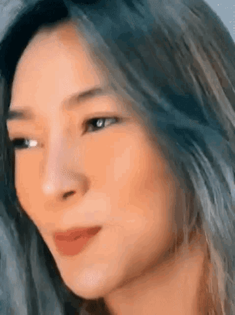 a close up of a woman 's face with long hair and a red lip .