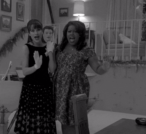 two women standing next to each other in a room