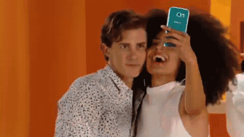 a man and woman are taking a selfie with a phone that says samsung on it