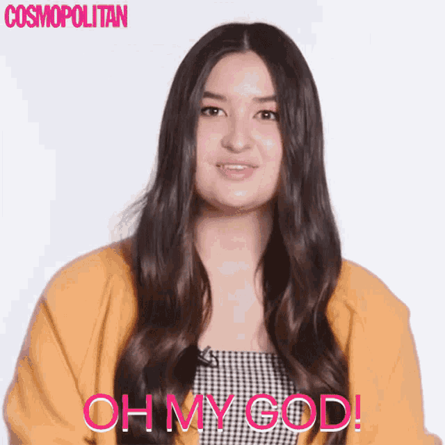 a woman wearing a yellow cardigan and a black and white dress says oh my god