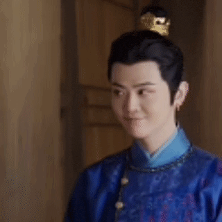 a man in a blue robe and a crown on his head is smiling .