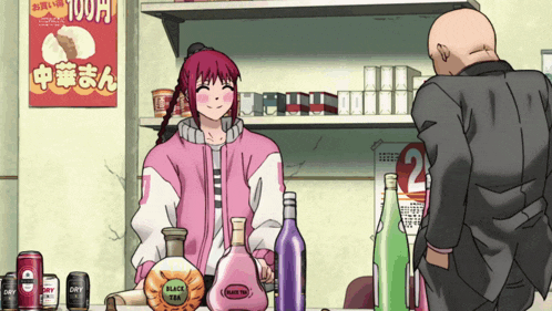 a woman in a pink jacket stands behind a counter with bottles of black tea and martini on it