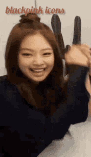 a girl with a bun in her hair is holding a knife in her hand with the words blackpink icons behind her