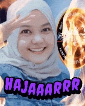 a woman wearing a hijab is smiling with a coin in the background that says ' bintang ' on it