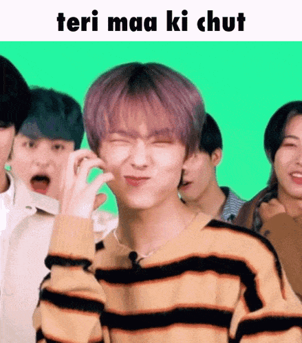 a man in a striped sweater is making a funny face while standing in front of a group of people .