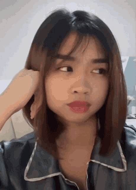 a close up of a woman 's face with a hand on her head