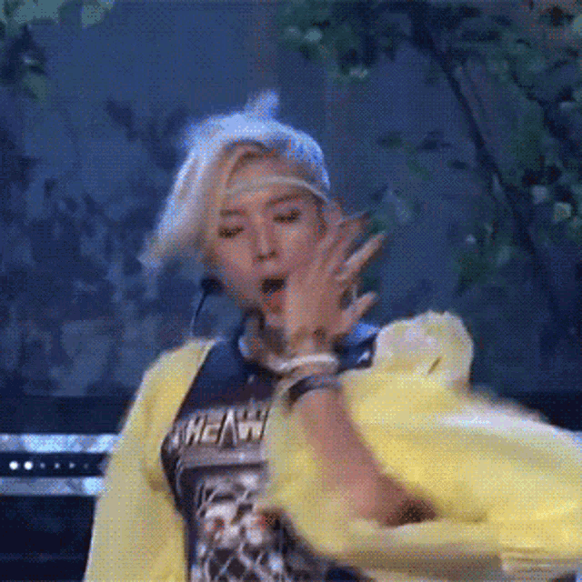 a woman wearing a yellow jacket and a black shirt that says heavy
