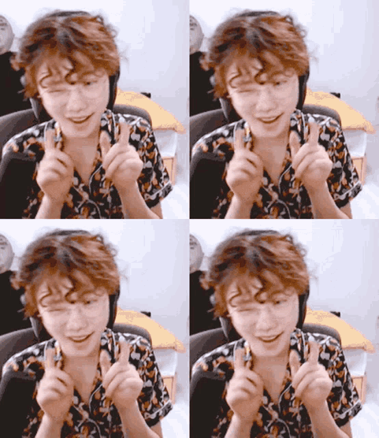 a man with curly hair is wearing headphones and making a heart shape with his fingers