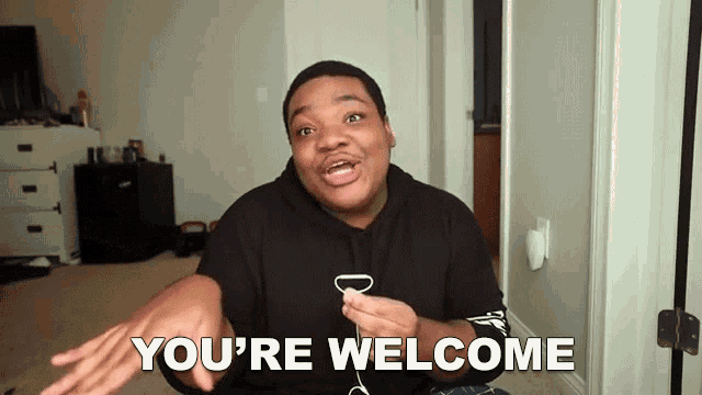a man says " you 're welcome " in front of a white wall