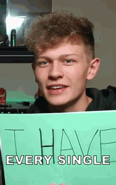 a young man is holding a sign that says i have every single