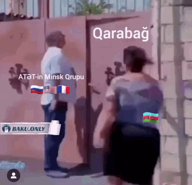a man and a woman are standing in front of a gate with qarabag written on the top